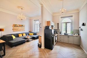 a kitchen and a living room with a black refrigerator at Apartment Nicol in Karlovy Vary