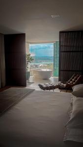 a bedroom with a bath tub and a large window at Rancho CB in Santo Antônio do Descoberto