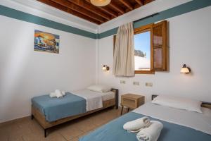 two beds in a room with a window at Villa Sakura in Lindos