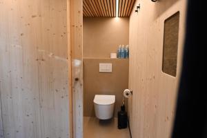 La salle de bains est pourvue de toilettes et d'un mur en bois. dans l'établissement Green Tiny Village Harz - Tiny House Pioneer 10, à Osterode
