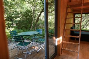 um pátio com uma mesa e cadeiras num deque em Green Tiny Village Harz - Tiny House Nature 13 em Osterode