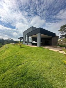 a house on a hill with a green lawn at Rancho CB in Santo Antônio do Descoberto