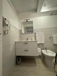 a white bathroom with a sink and a toilet at la casa di NU in Bisceglie