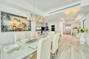 jadalnia ze szklanym stołem i białymi krzesłami w obiekcie 2288 new modern penthouse with privat pool w mieście Estepona