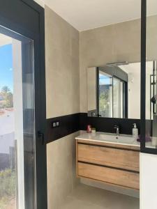 un bagno con lavandino e specchio di Modern House with City View in El Mas Fumats a La Selva de Mar