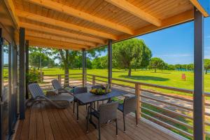 a patio with a table and chairs on a deck at Holiday Mobile Homes Park Riviera in Novigrad Istria