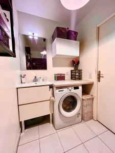 a bathroom with a washing machine and a sink at Apt central entre stade de France et villette in Aubervilliers