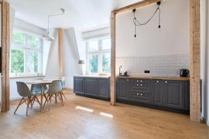 a kitchen with gray cabinets and a table and chairs at DR Apartments - Parkowa in Sopot +11 photos