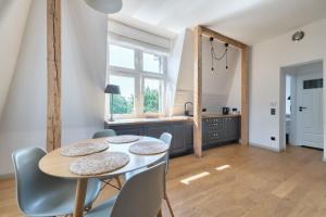a kitchen and dining room with a table and chairs at DR Apartments - Parkowa in Sopot