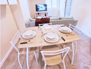 a dining room table with chairs and a couch at Le Mahanaim House in Nevers