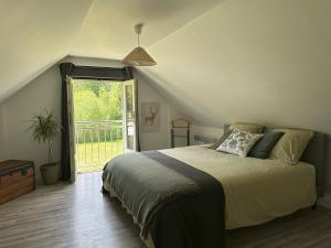 a bedroom with a bed and a large window at Le refuge de Chambord Nature, calme, forêt et prestige des châteaux de la Loire in Thoury