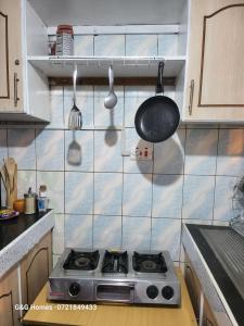 a kitchen with a stove and a pan and utensils at G&G Homes Nakuru CBD in Nakuru +12 photos