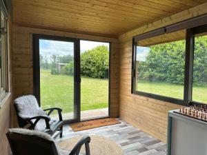 a screened in porch with a view of a yard at Le refuge de Chambord Nature, calme, forêt et prestige des châteaux de la Loire in Thoury