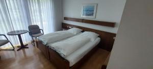 a bedroom with a bed with a table and a chair at Hotel zur Kroner Heide in Greven