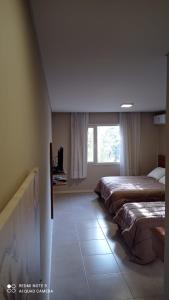 ein Schlafzimmer mit zwei Betten und einem Fenster in der Unterkunft Rincón del Sol in Pinamar