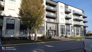 ein Apartmenthaus mit einem Baum davor in der Unterkunft Rincón del Sol in Pinamar