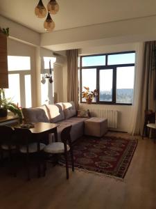 a living room with a couch and a table at Элитная 2х комнатная квартира на набережной c видом на ботаничнеский сад 6мкр in Bishkek
