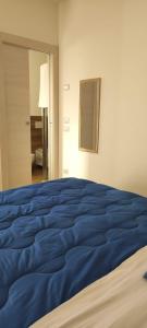 - un grand lit bleu dans une chambre blanche dans l'établissement B&B Casa Alysa, à Tavullia