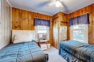 a bedroom with wooden walls and a bed and a tv at Seaside Cottage in Wells