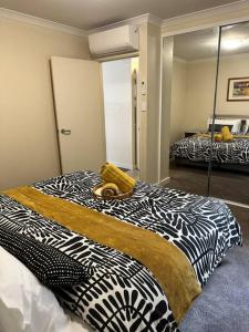 a bedroom with a black and white bed with a mirror at Perth city BNB l CBD and Pool view - 1xKing bed and 2xSingle beds in Perth