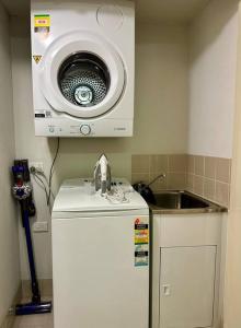 a kitchen with a microwave on top of a refrigerator at Perth city BNB l CBD and Pool view - 1xKing bed and 2xSingle beds in Perth