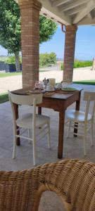 a wooden table and chairs on a patio at Casa Alysa Agriturismo in Tavullia