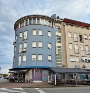 a tall blue building with a table in front of it at Studio apartman Zubak in Ðakovo