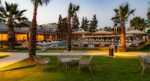 a resort with a pool and chairs and palm trees at Suum Bodrum Hotel & Beach - Adult Only in Bodrum City +94 photos