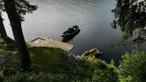 two boats in a body of water with a dock at Moderne hytte i vannkanten med tilgang til brygge og båt in Risør