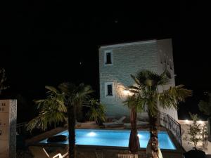 a villa with a swimming pool at night at Regina Maris in Betina