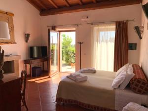 a bedroom with a bed and a sliding glass door at Resort Fonte Vulci in Canino
