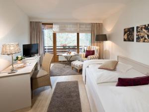 una camera d'albergo con 2 letti e una scrivania di Romantischer Winkel RoLigio & Wellness Resort a Bad Sachsa