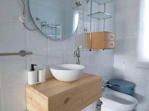 a bathroom with a sink and a toilet and a mirror at Casita tranquila, con finca y cerca de las playas in Muxia +36 photos