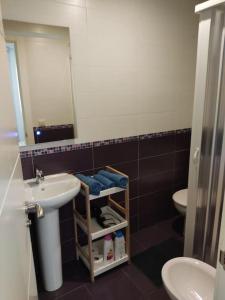 Un baño con lavabo, inodoro y espejo. en Loft Albergueria, en Zamora