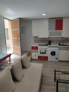 Una sala de estar con un sofá blanco y una cocina. en Loft Albergueria, en Zamora