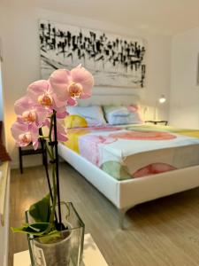a bedroom with a bed and a vase with flowers at Residenza d'Artista al Duomo1 in Salerno