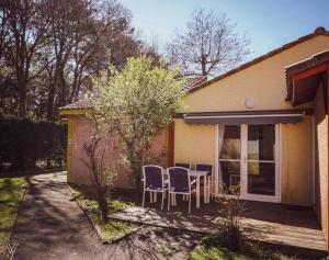 a patio with chairs and a table outside of a house at Maison charmante à Soustons avec piscine et jardin in Soustons