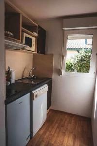 a small kitchen with a sink and a window at Maison charmante à Soustons avec piscine et jardin in Soustons