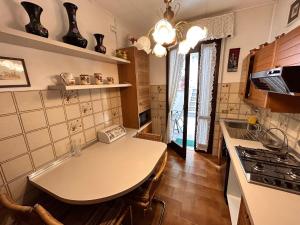 a small kitchen with a table and a stove at Appartamento BIANCA in Toscolano Maderno