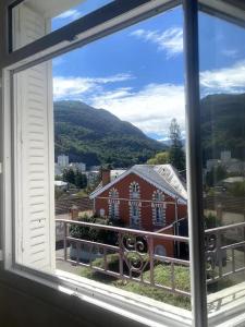 a view of a red barn from a window at Appartement Altea 85 m2 climatisé parking proche Sanctuaires in Lourdes +11 photos