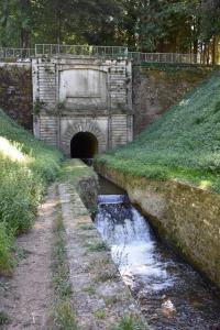 a stone tunnel with a bridge over a river at Maison de village in Les Cammazes