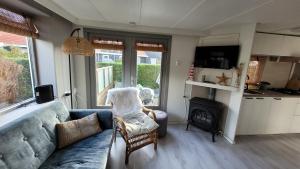 a living room with a couch and a fireplace at Chalet Joy aan Zee in Hollum +16 photos