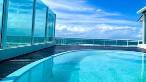 a swimming pool on a building with a view of the ocean at CASA COM PISCINA À BEIRA MAR. in Recife