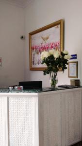 ein Tisch mit einer Blumenvase darauf in der Unterkunft La Coupole Hotel in Quito