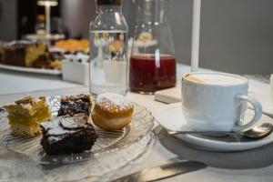a table with a plate of pastries and a cup of coffee at TORTE & LINI in Bologna