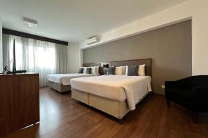 Postel nebo postele na pokoji v ubytování Hotel Deville Curitiba