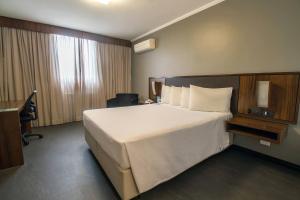 Postel nebo postele na pokoji v ubytování Hotel Deville Curitiba