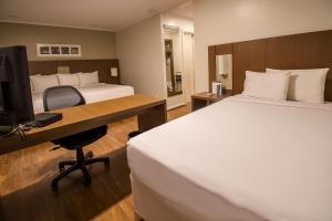 Postel nebo postele na pokoji v ubytování Hotel Deville Curitiba