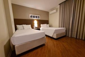 Postel nebo postele na pokoji v ubytování Hotel Deville Curitiba