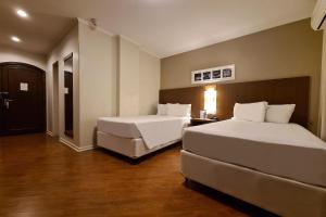Postel nebo postele na pokoji v ubytování Hotel Deville Curitiba